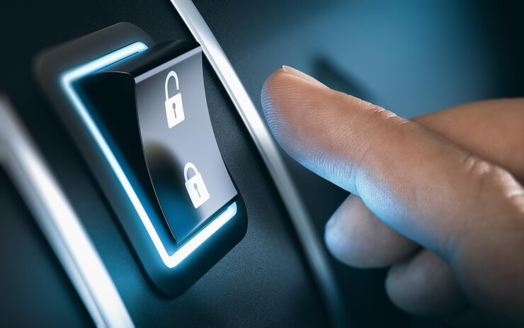 Photo finger about to press a car lock button. black background
