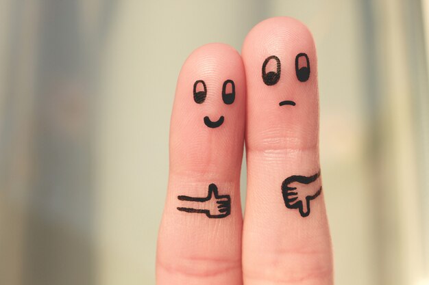 Finger art of couple. Woman showing thumbs up and man showing thumbs down.