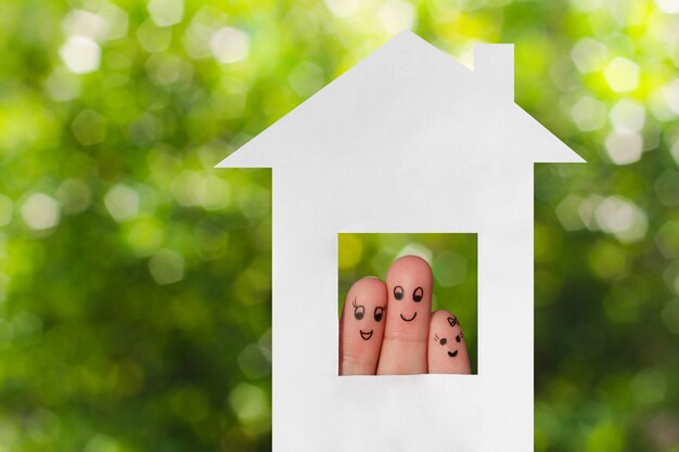 Finger art of a family. Family looking out of house 