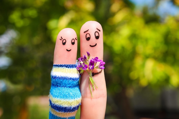 Foto arte del dito di una coppia felice. l'uomo sta dando fiori donna incinta.