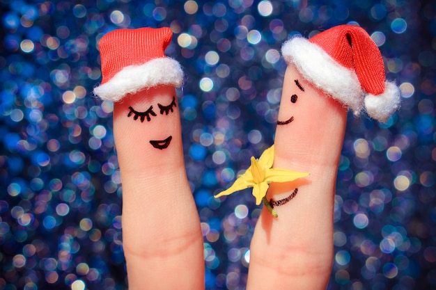     Finger art of Happy couple. Man is giving flowers to woman 