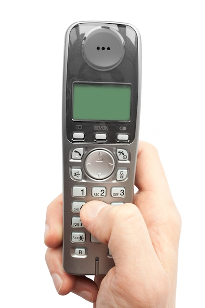 Finger dials a phone number on a cordless telephone