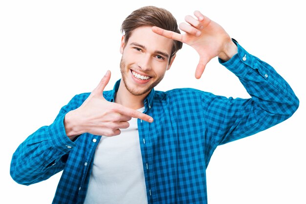 Finger frame. Handsome young man gesturing a finger frame and looking at camera