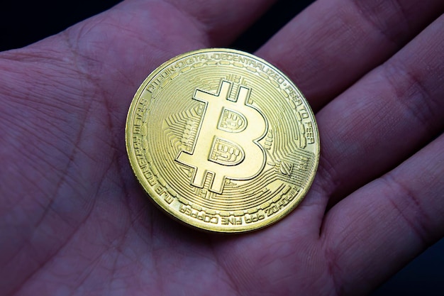 Finger hold bitcoin golden on black isolated Hand hold gold bitcoin crypto ditital money concept