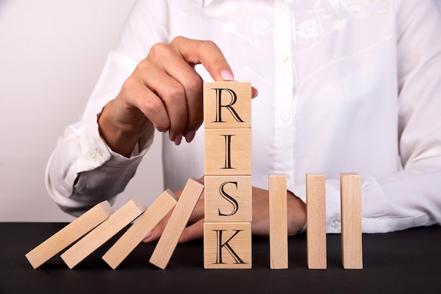 The finger holds wooden cubes Risk management concept