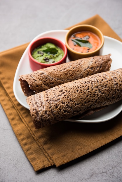 Photo finger millet orãâ ragi dosaãâ is a healthy indian breakfast served with chutney, in roll, flat or cone shape