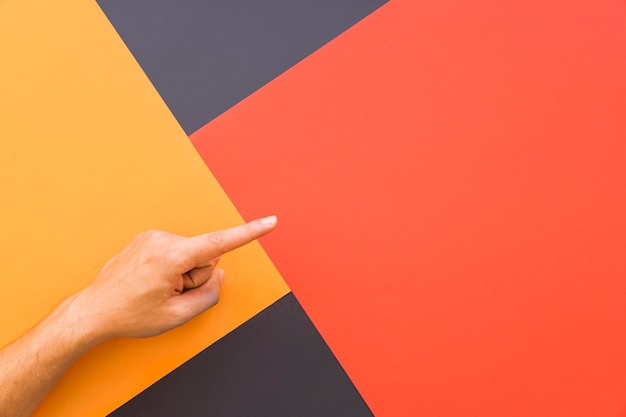 Finger pointing above geometric background