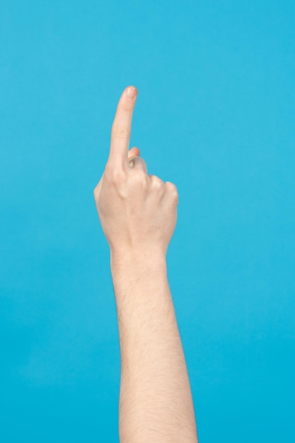 Photo finger pointing up on blue background