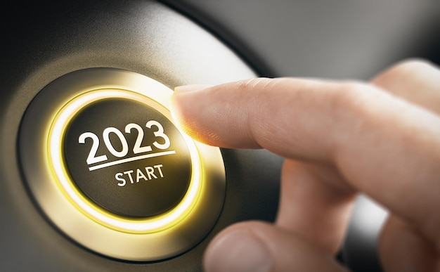 Finger pressing a car ignition button with the text 2023 start Year two thousand and twenty three