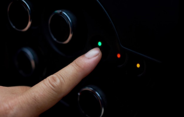 A finger pressing a green light on a steering wheel