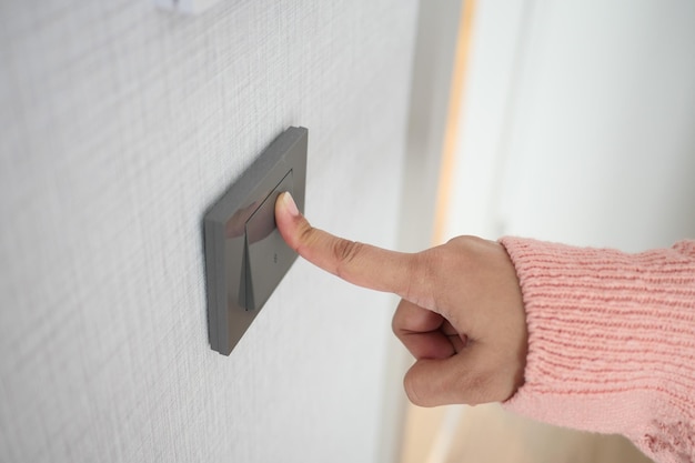 A finger turning on lighting switch