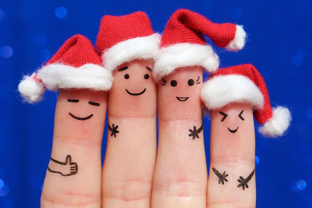 友達の指アートはクリスマスを祝う新年の帽子で笑う人々のグループのコンセプト