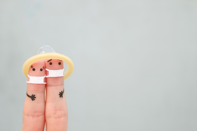 Photo fingers art of happy couple in medical mask from covid-2019. concept of safe sex.