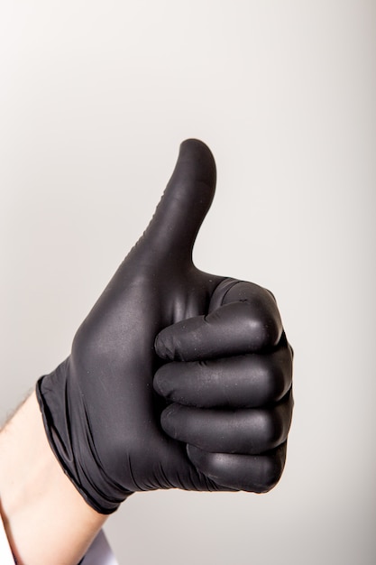 Fingers symbol good. Isolated on white. Healthy medicine concept. Sign made of black medical gloves.