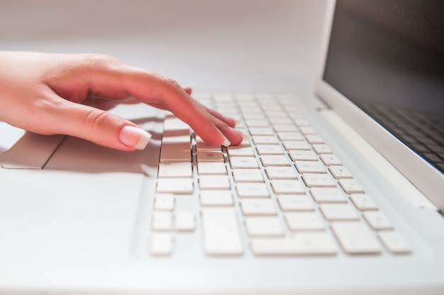 Photo fingers of woman pressing laptop keys