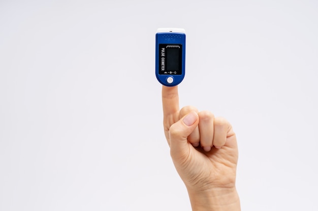 Fingertip Pulse Oximeter on finger. On white background. Device for self health diagnostic.