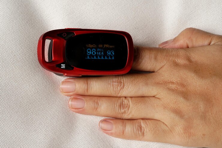 Photo fingertip pulse oximeter measuring at the female index finger