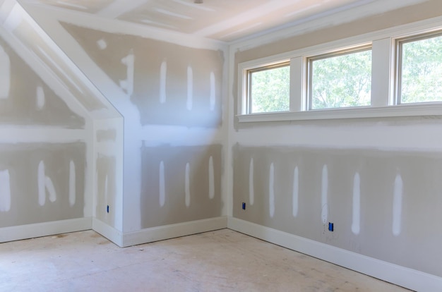 Photo finishing plastering drywall in ready for paint with new house under construction