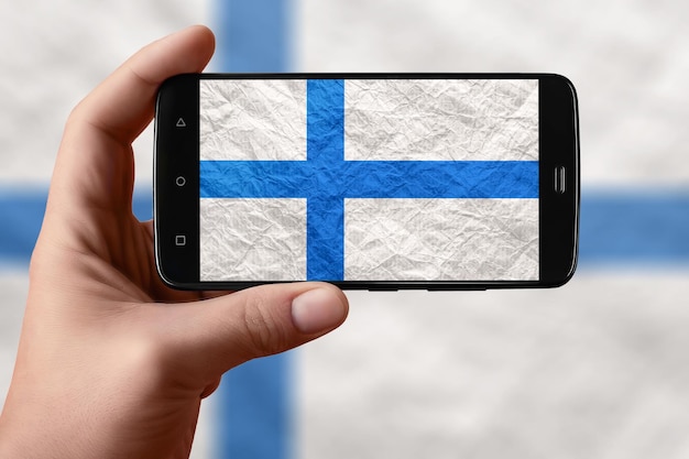 Finland flag on the phone screen Smartphone in hand photographing flag