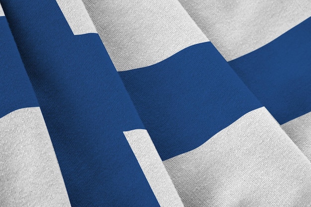 Finland flag with big folds waving close up under the studio light indoors The official symbols and colors in banner