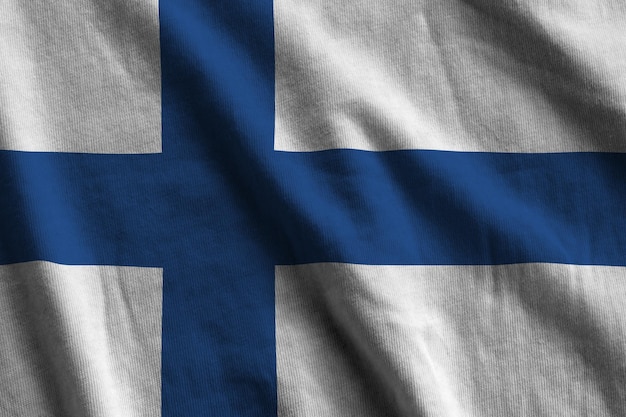 Finland flag with big folds waving close up under the studio light indoors The official symbols and colors in banner