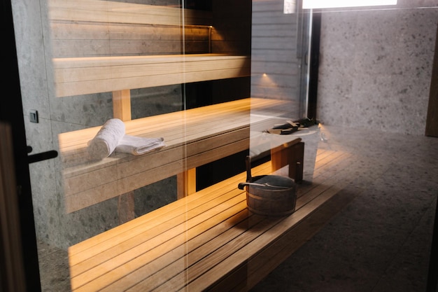 Финская ванная комната с небольшой деревянной сауной, фото интерьера современного спа через стеклянную дверь