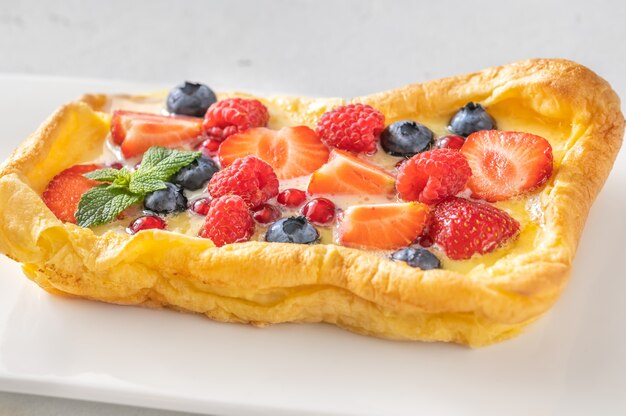 Finnish pancake topped with fresh berries and mint