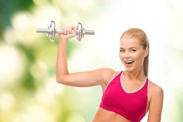 fintess, healthcare and dieting concept - young sporty woman with heavy steel dumbbell