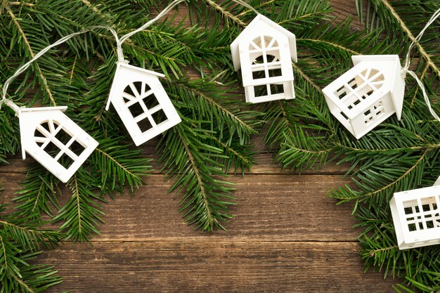 Fir branch and a garland of white small houses.