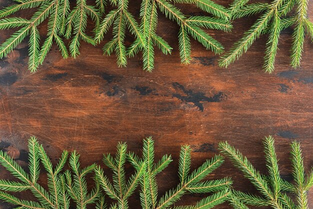 Fir branch op houten vintage Kerstmis achtergrond. Winter bruine achtergrond van kerstsparren en sparren takken op houten tafel, plat lag en bovenaanzicht. Kerstmis en Nieuwjaar grens