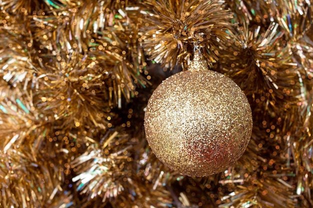 金色の輝きとクリスマスの背景にボールとお祝いのライトとモミの枝