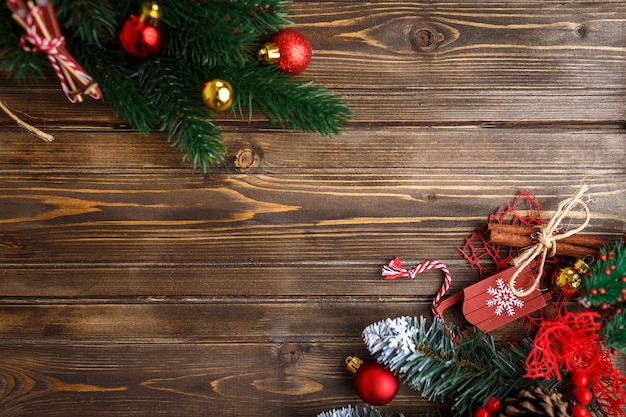 Fir branch with Christmas decorations on old wooden brown background with copy space for text