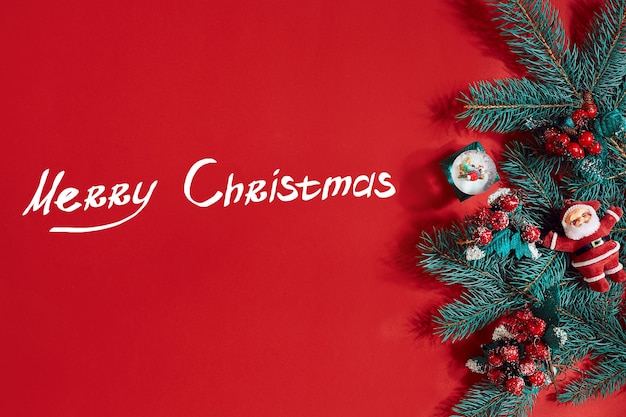 Fir branches border on red background, good for christmas backdrop. Top view. Flat lay. Copy space. Still life. The inscription - Merry Christmas and New year