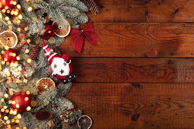 モミの枝のクリスマスの装飾と古い木製の背景のクリスマスの金色のライト