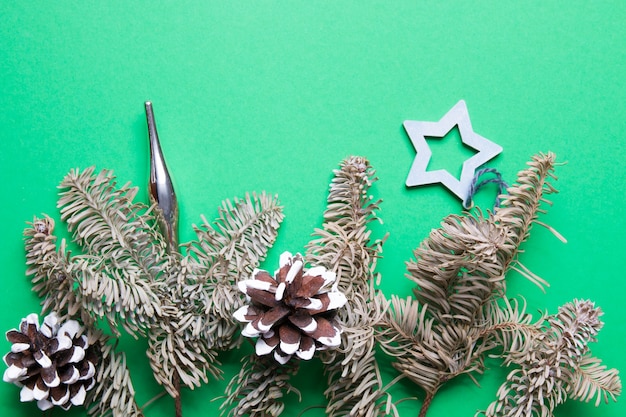 еловые ветки и рождественский эко-декор на зеленом фоне копией пространства
