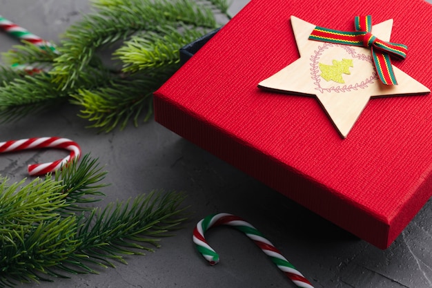 Fir branches on concrete gray background with red gift box and decorations