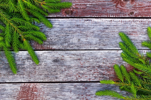 Fir branches lie on a wooden background The background is made of aged boards taupe horizontal photograph