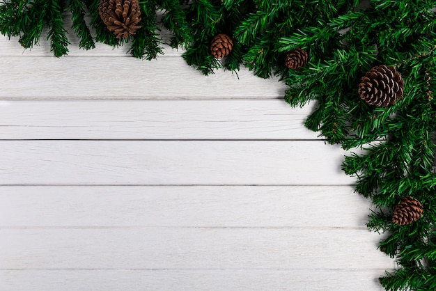 Fir branches and Pine cones on white wooden board