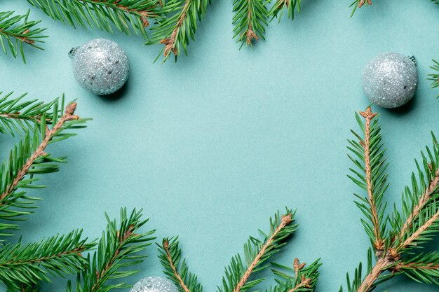 Fir, spruce branches and Christmas tree toys on green with copy space