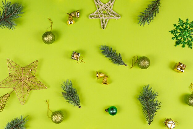 Fir tree branches and Christmas decorations on green background