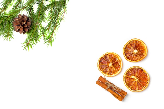 Fir tree branches, pine cones and dried orange fruits, cinnamon stick isolated on a white background