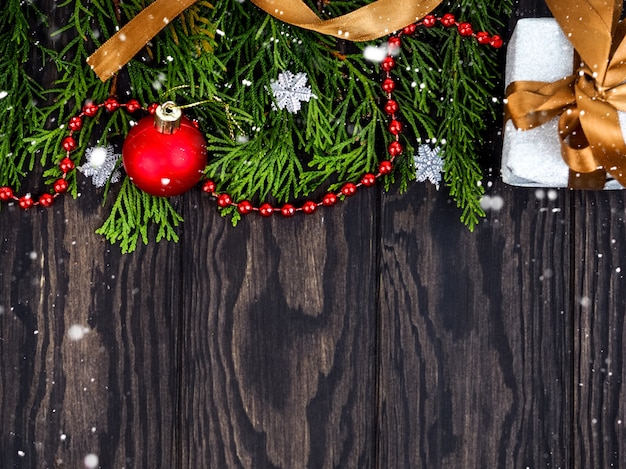 Fir tree branches with Christmas decoration on wood