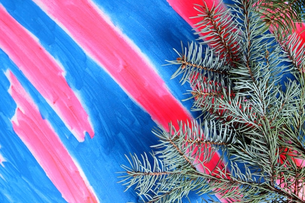 Fir tree branchs on a pinkblue background View from above Closeup Blank space for signature