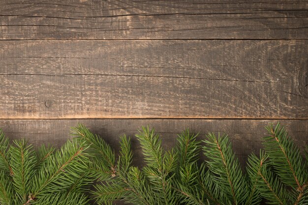 Photo fir tree branchs on wooden table, flat lay