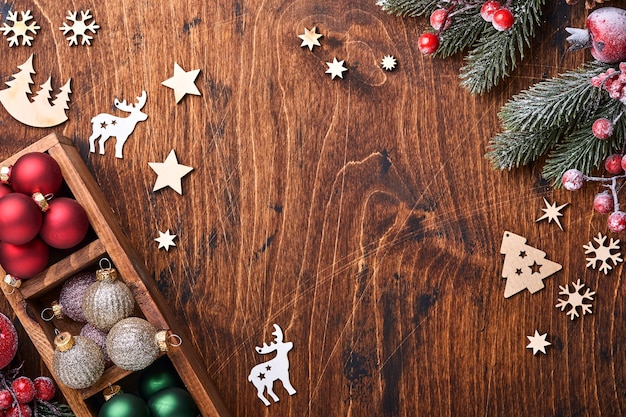 Palle di natale rosse e verdi della decorazione dell'albero di abete, cannella sagomata e fette di arance secche su fondo di legno per i vostri auguri di natale. vista dall'alto con copia spazio. biglietto di auguri di natale.