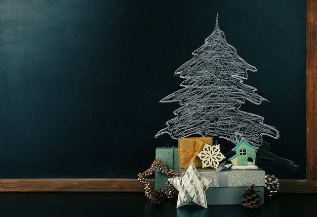 Fir tree tekening op blackboard en mooie geschenken. kerst achtergrond