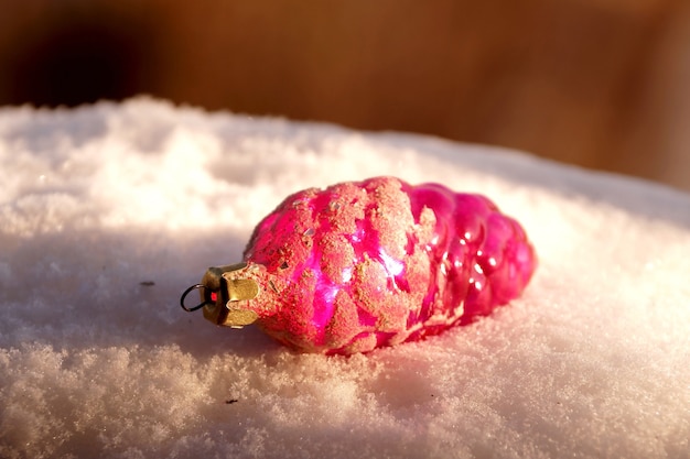 Giocattolo di abete a forma di cono di vetro rosa sulla neve