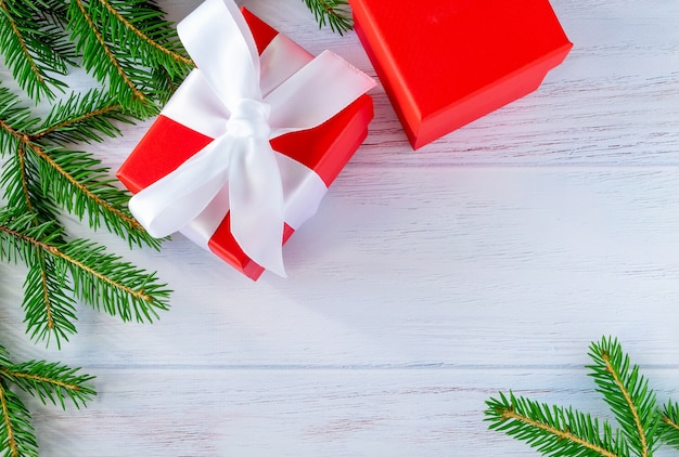 Fir twigs and gifts are laid out on a wooden surface painted blue. Christmas, New Year 