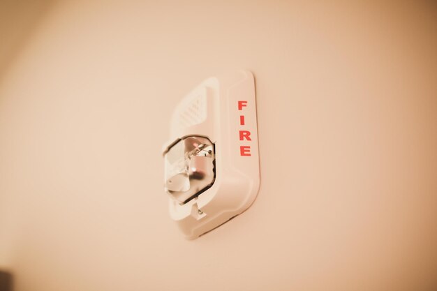 A fire alarm on a wall with the word fire on it