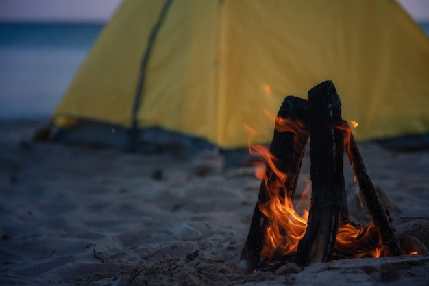 Fire in bonfire in the beach Camping and tents to travel